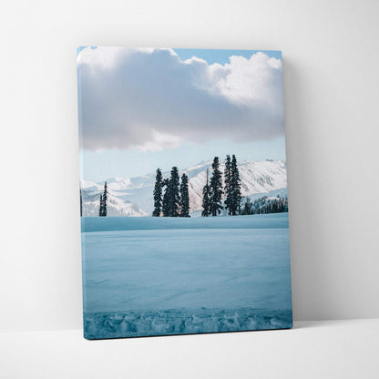 Snowy winter landscape canvas wall art with tall pine trees and snow-covered mountains.