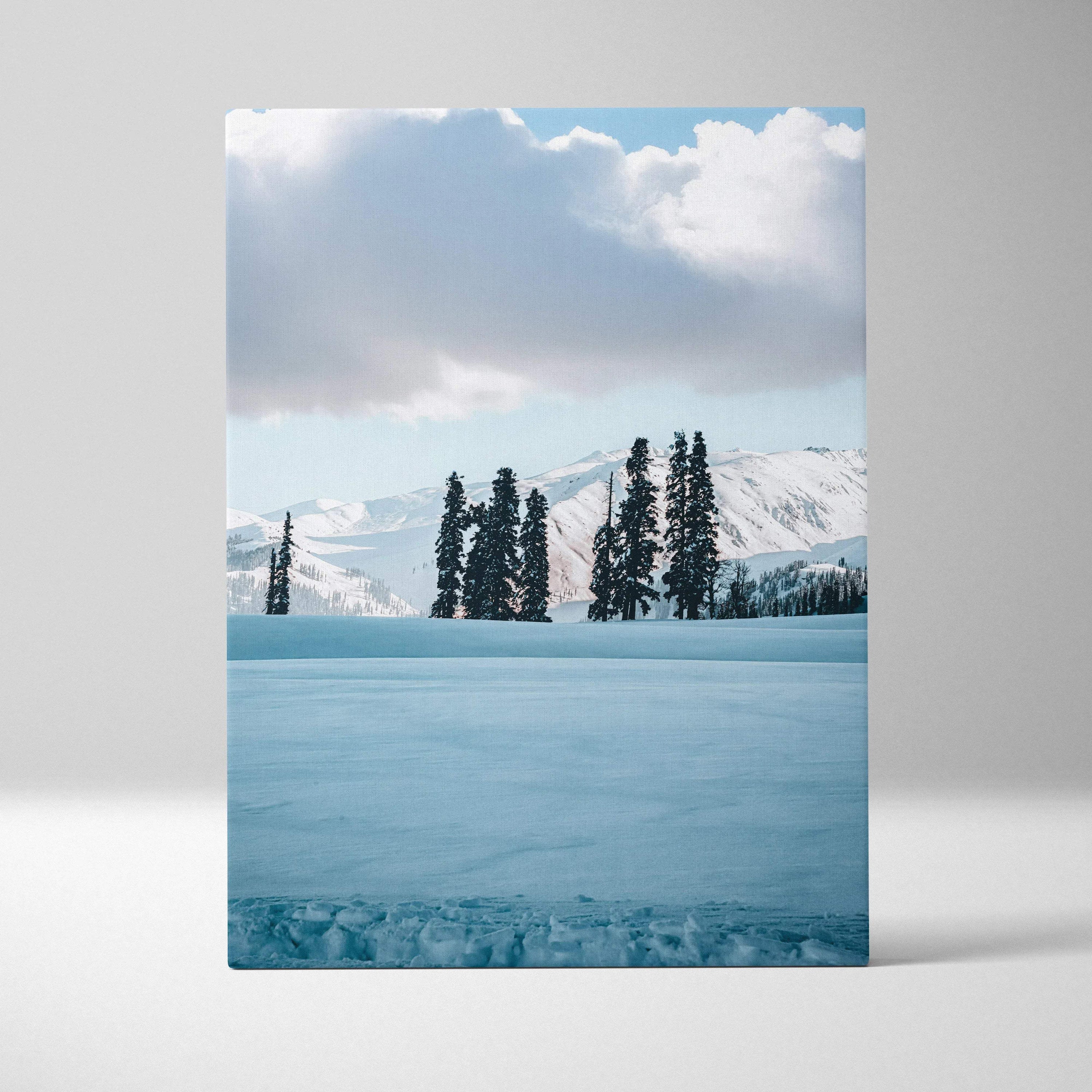 Snowy mountain landscape with tall pine trees under cloudy sky canvas wall art.