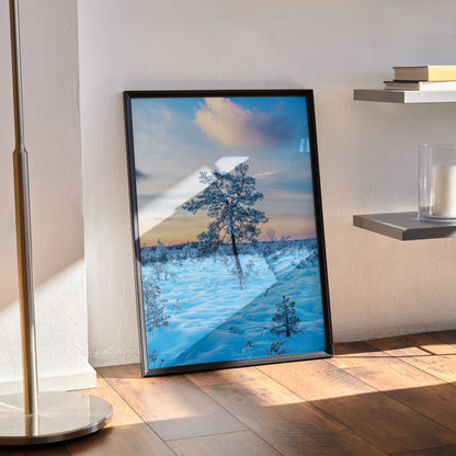 Serene snowy landscape poster with lone tree and pastel sky wall art in black frame.