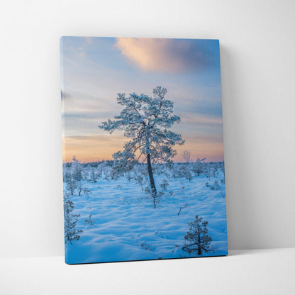 Snowy landscape with lone tree at sunset on vertical canvas wall art.