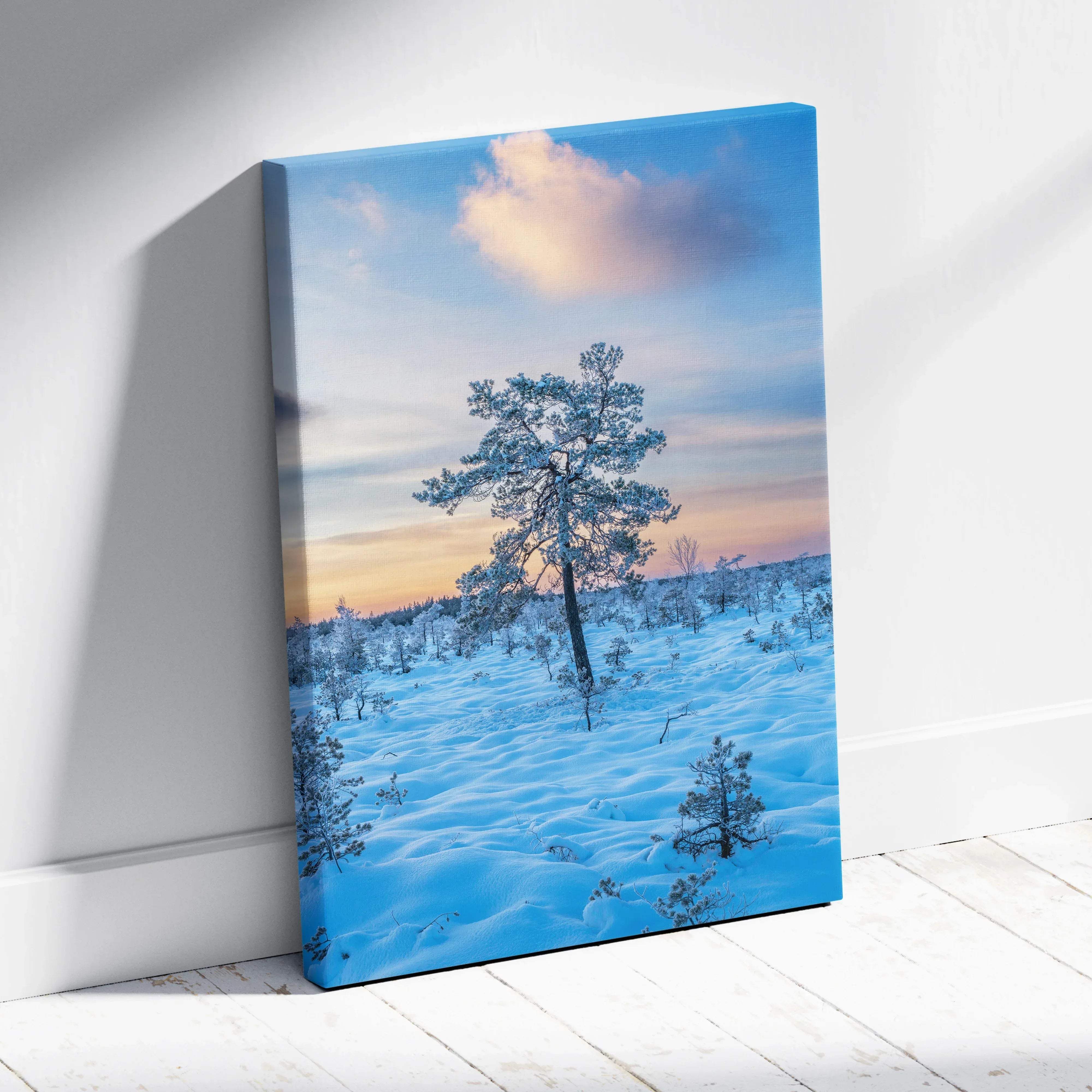 A framed canvas print of a solitary snow-covered pine tree against a pink and blue twilight sky with golden glow