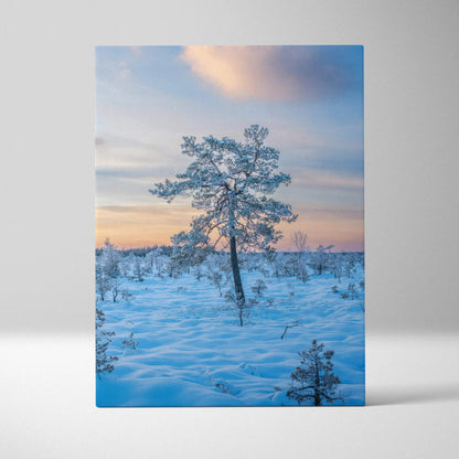 Canvas wall art featuring a snowy landscape with a lone tree under a colorful sunset sky.