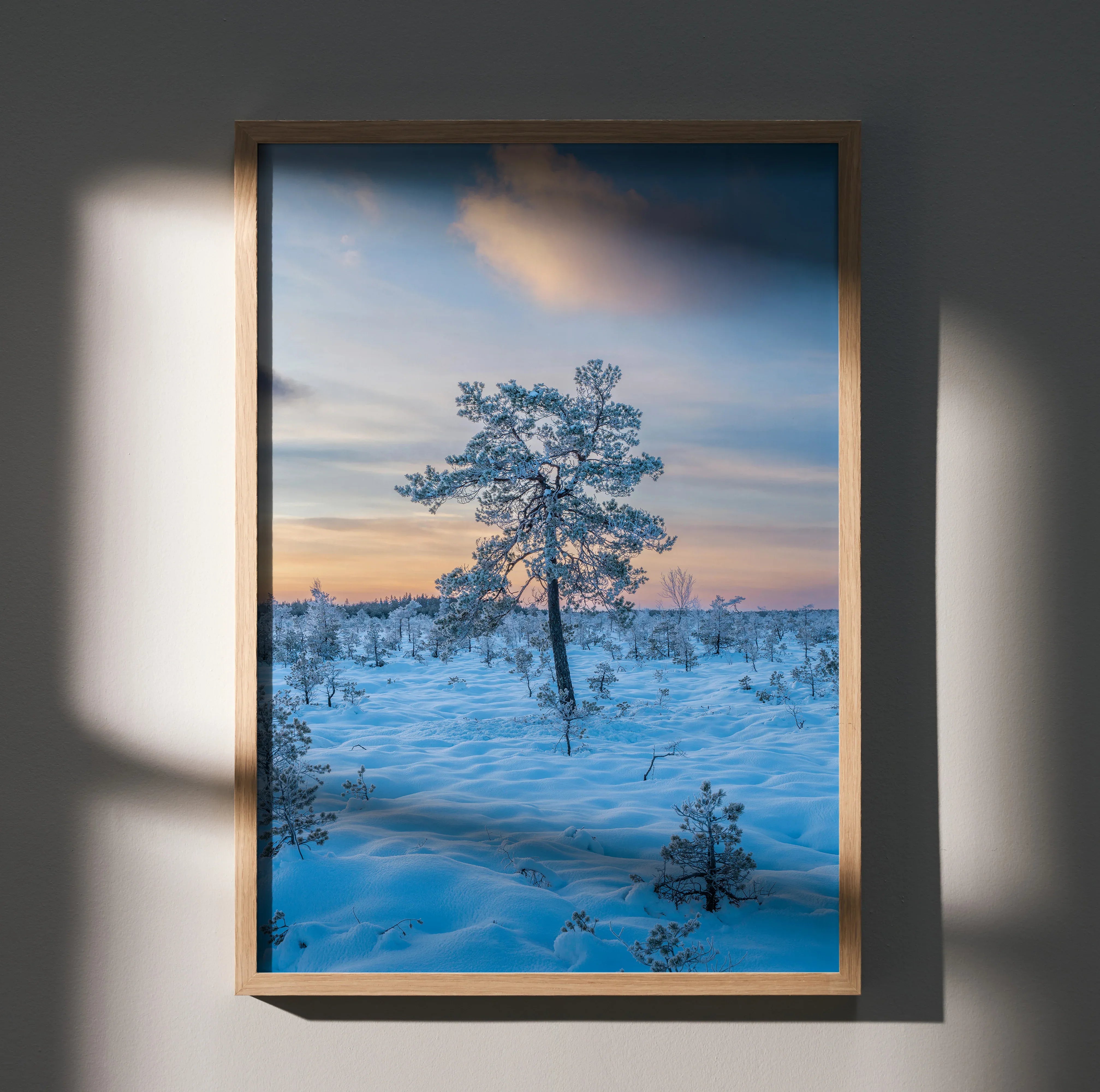 Serene snowy landscape poster featuring a lone tree at sunset, vertical wall art print.