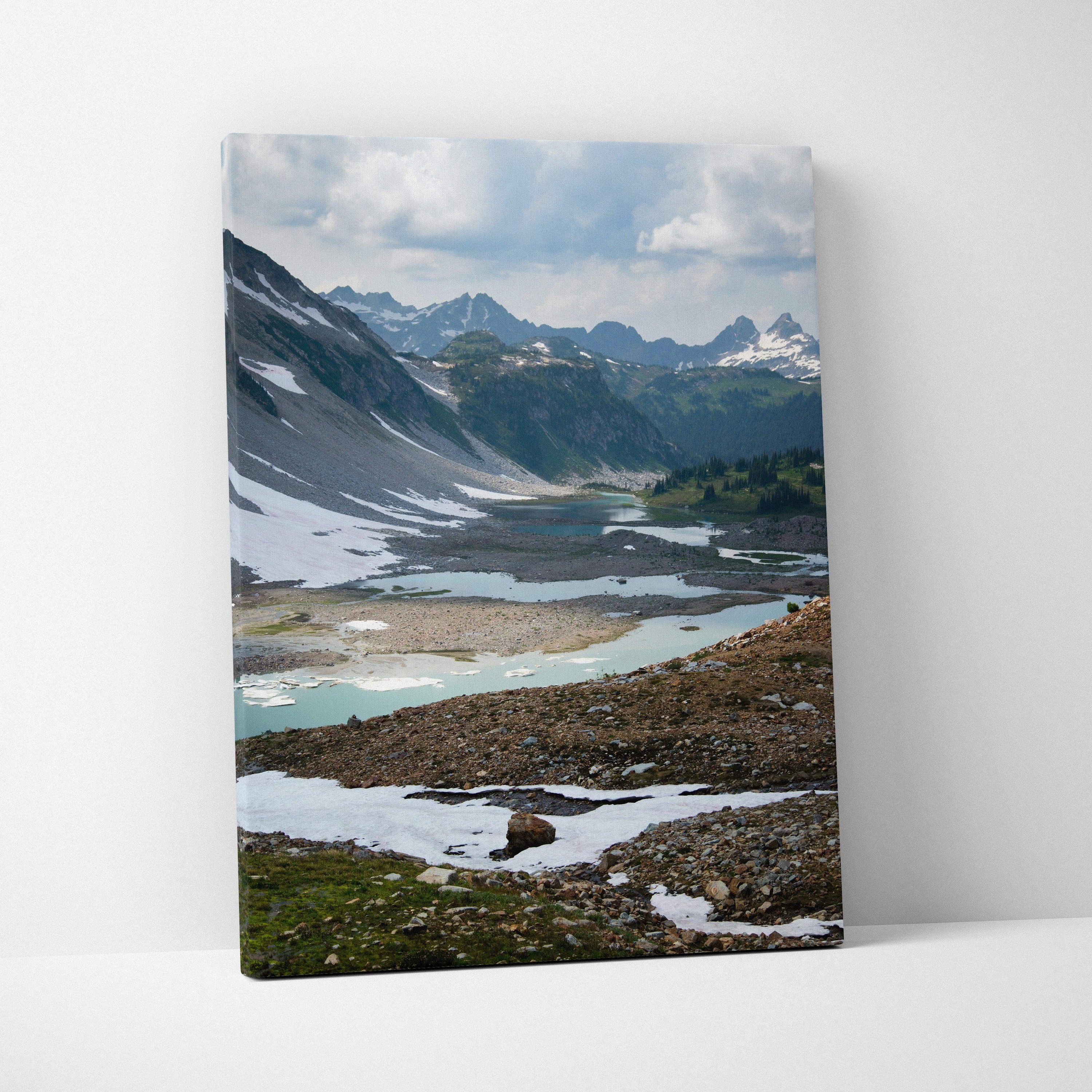 Canvas wall art featuring a breathtaking snowy mountain landscape with a partially frozen lake.