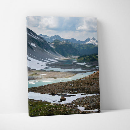 Canvas wall art featuring a breathtaking snowy mountain landscape with a partially frozen lake.