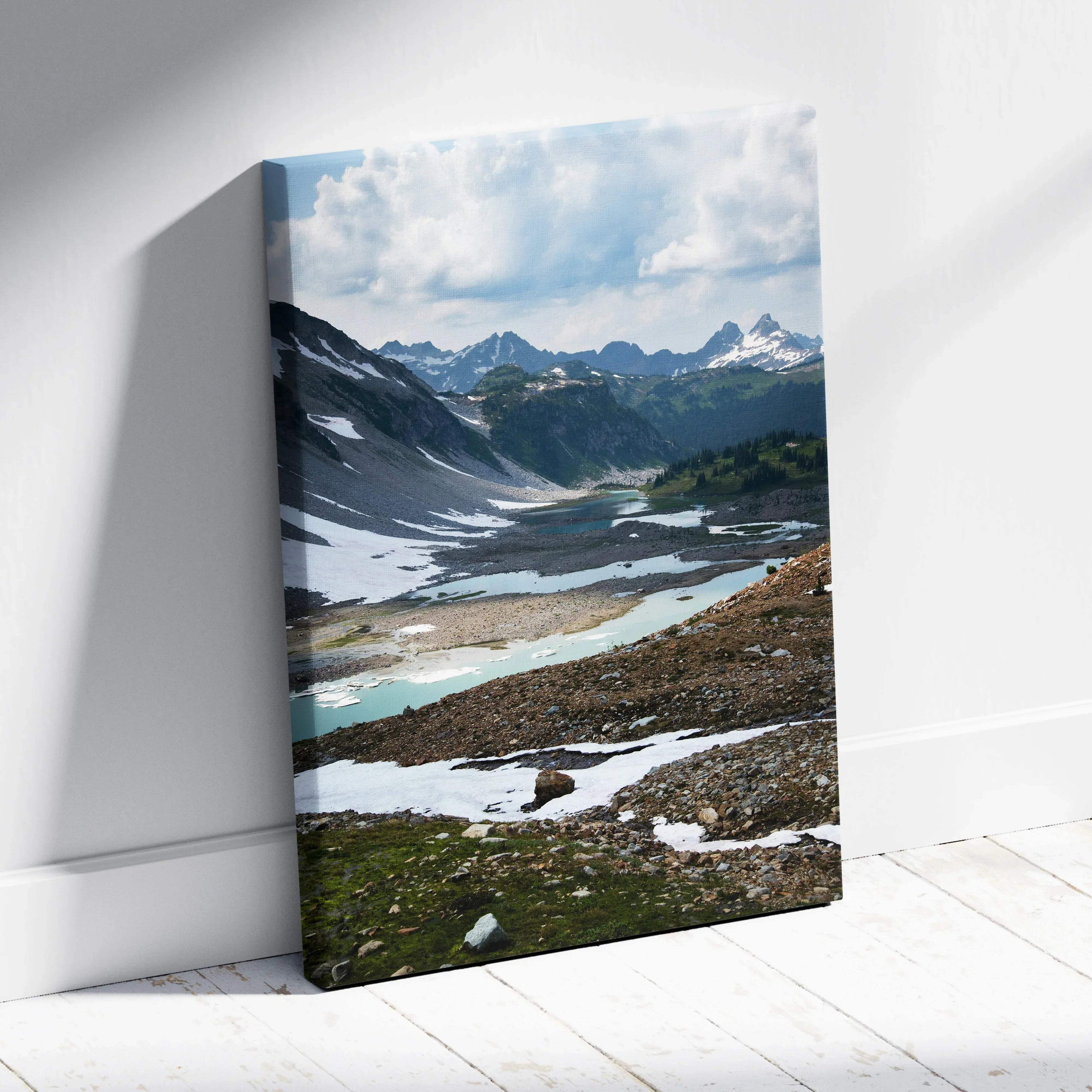 Mountain landscape canvas wall art with snowy peaks and a reflective alpine lake under a cloudy sky.