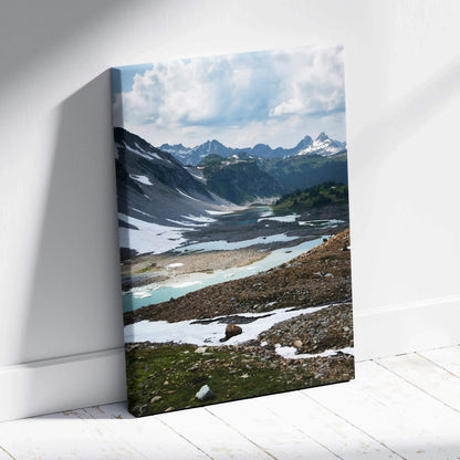 Mountain landscape canvas wall art with snowy peaks and a reflective alpine lake under a cloudy sky.