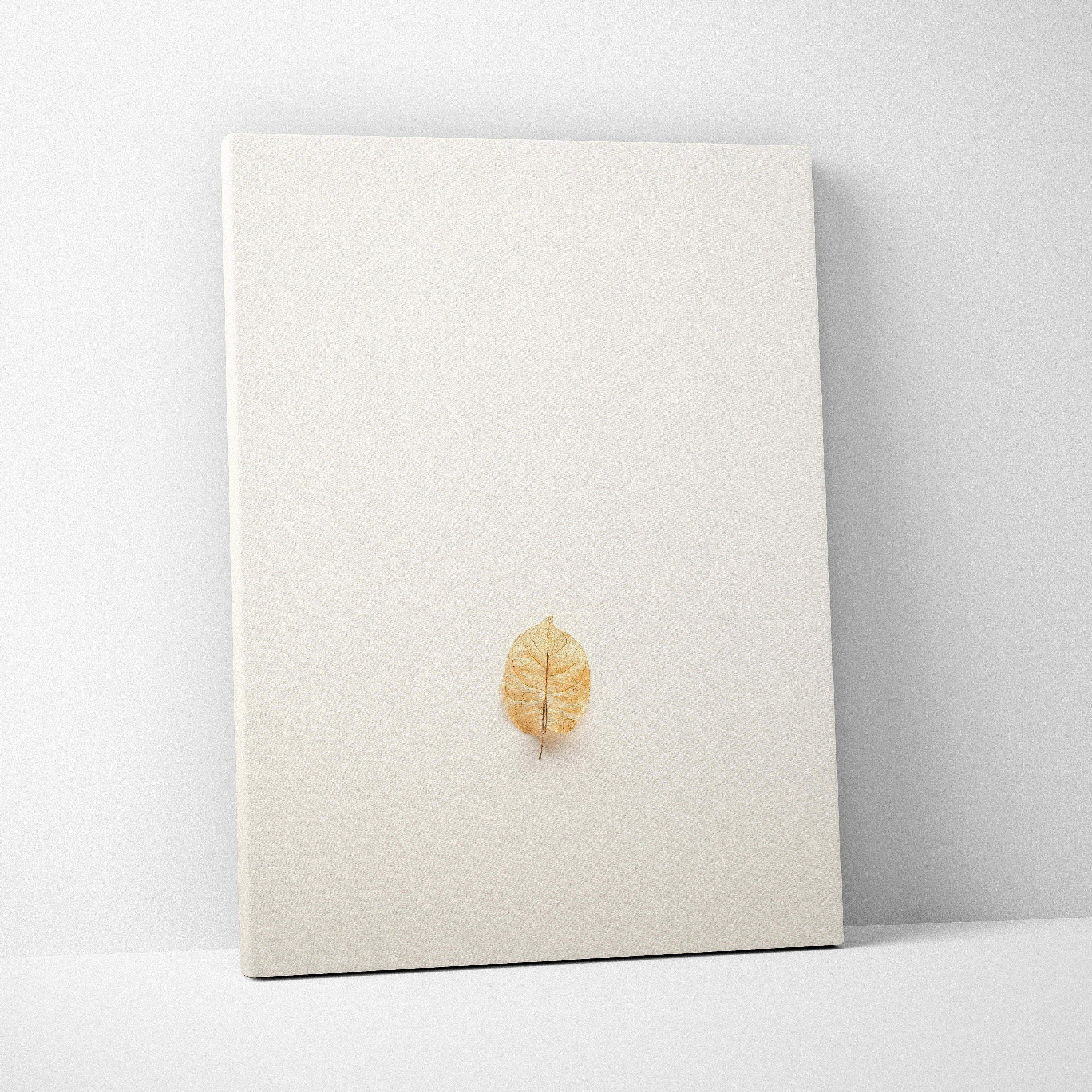 Minimalist golden-brown pressed leaf on warm beige canvas wall art