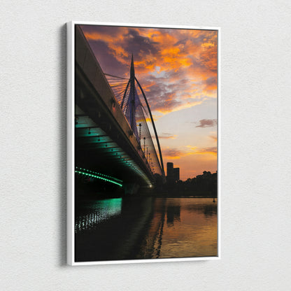 Canvas wall art of city skyline at golden sunset with illuminated bridge and reflective water.