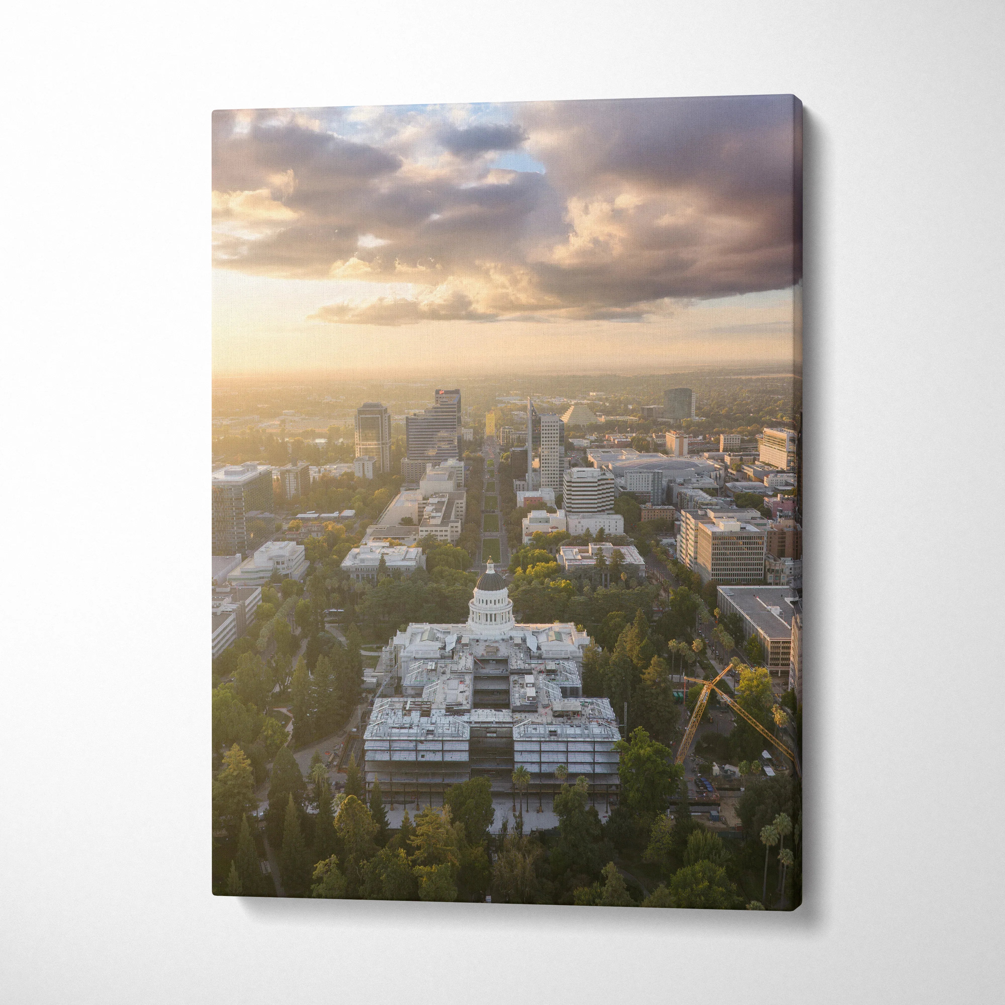 Vertical canvas wall art featuring a city skyline at golden sunset with soft clouds and warm light.