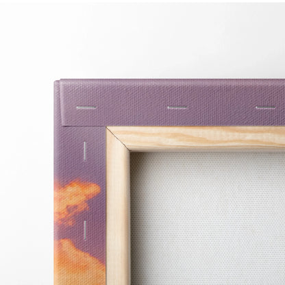 Close-up of canvas wall art corner with wooden frame and purple sunset sky print.