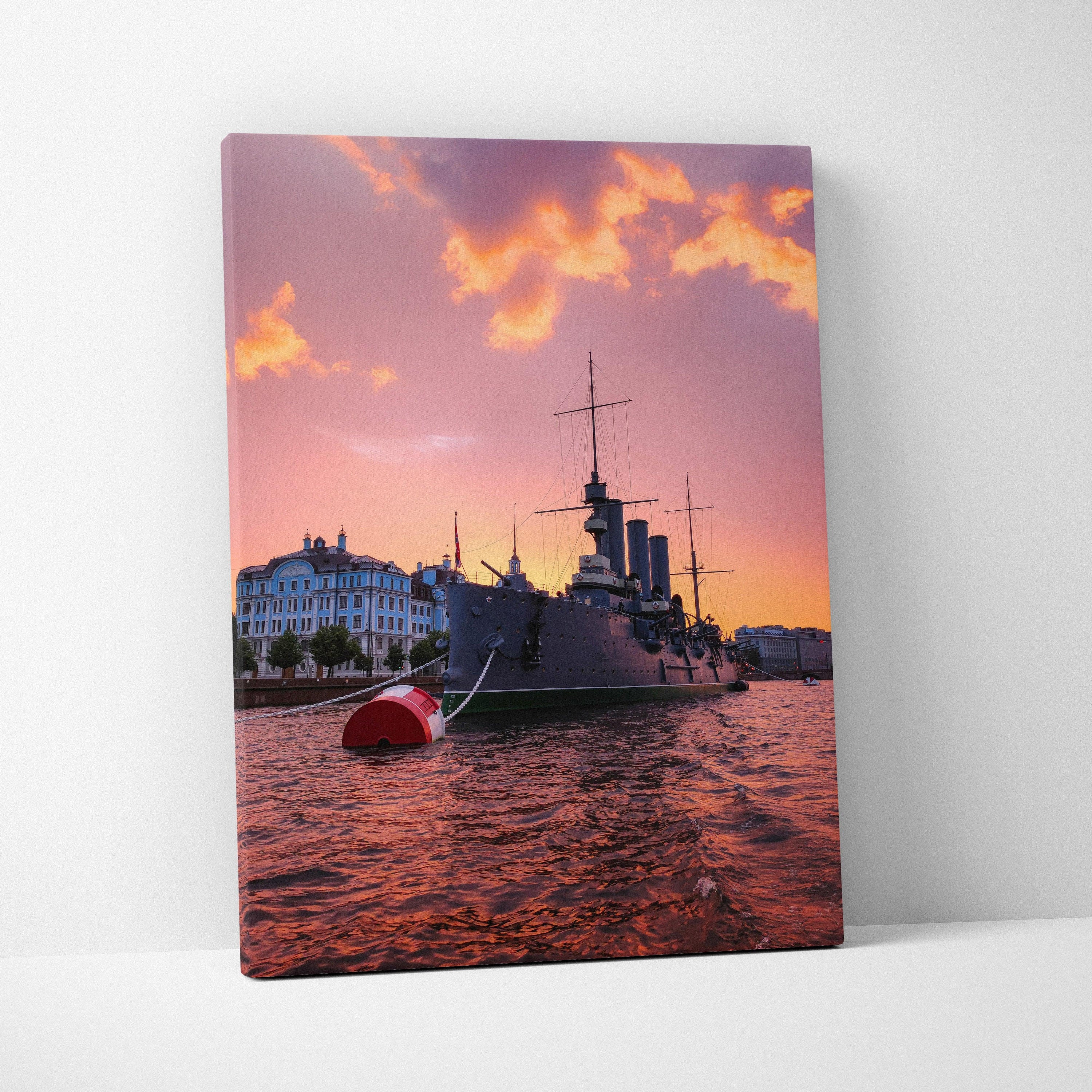 Canvas wall art featuring a city waterfront with a ship at sunset under vibrant orange and purple skies.