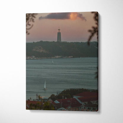 Sunset city skyline canvas wall art featuring a tall tower and sailboat on water.