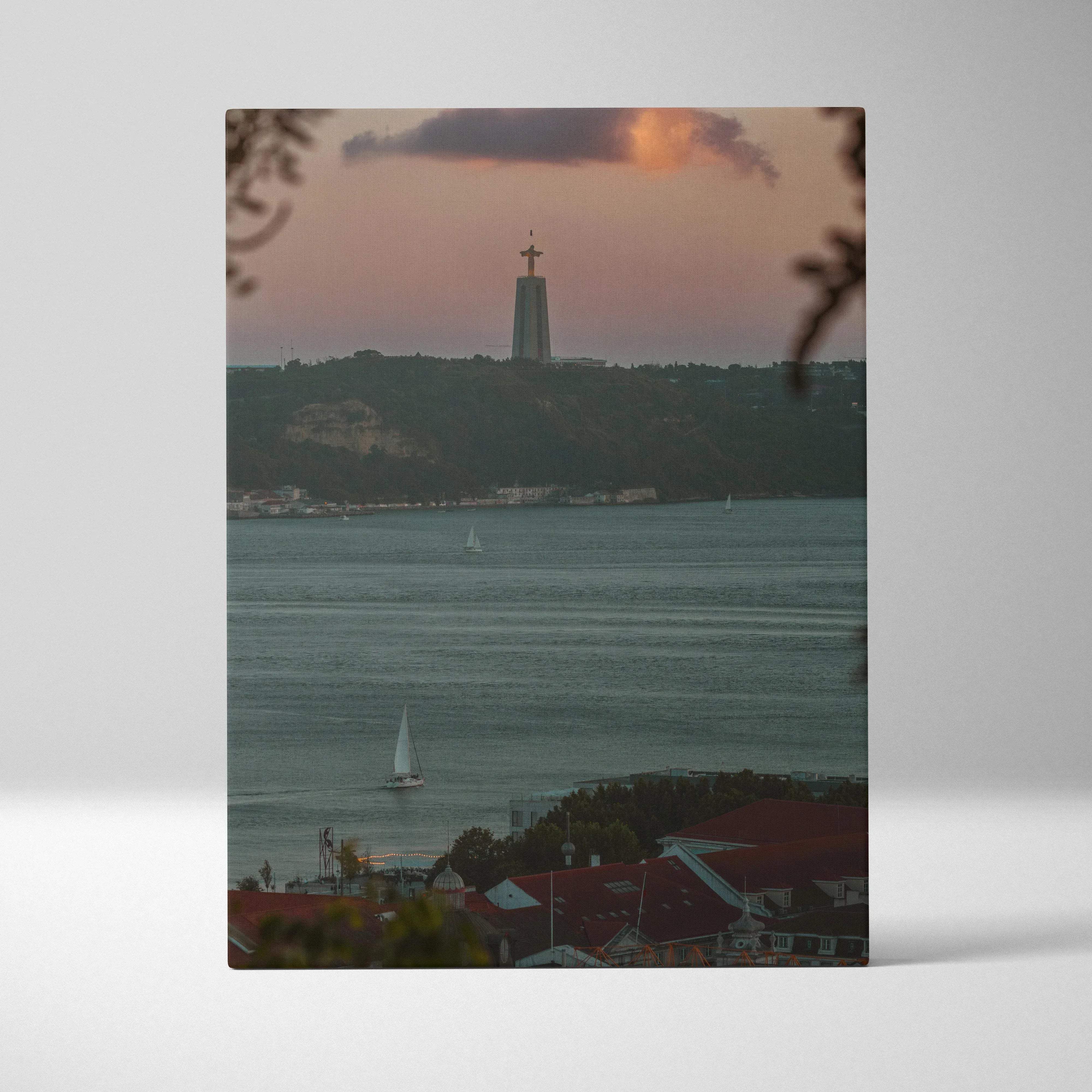 Rectangular canvas wall art featuring a serene sunset over water with sailboats and christ redeemer in the distance