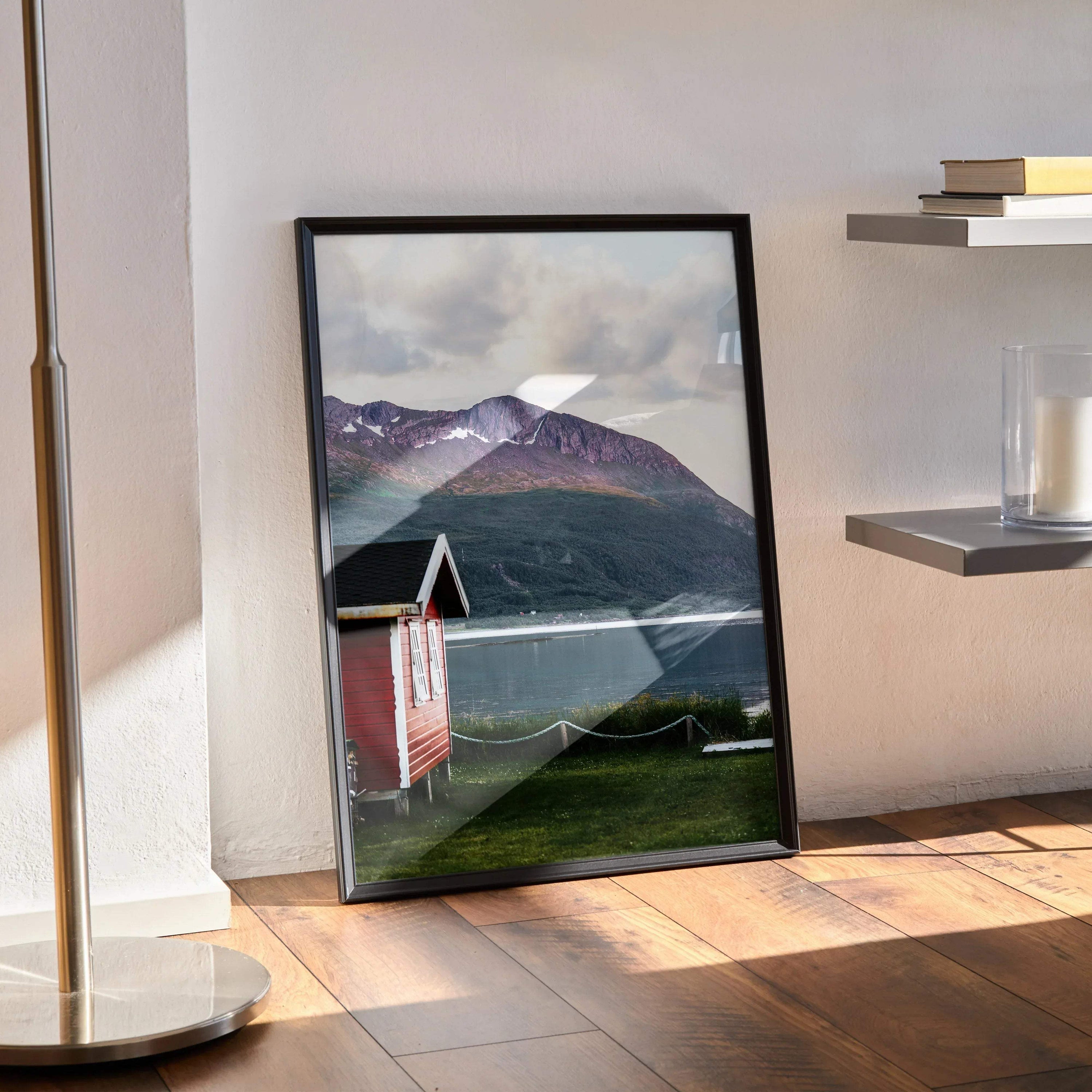 Vertical poster wall art featuring a red cabin by a lake with snowy mountain landscape background.