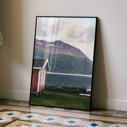 Vertical poster wall art featuring a red cabin by a lake with mountains in the background.