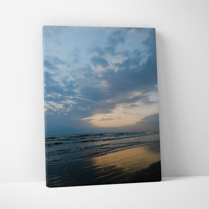 Canvas wall art featuring a serene beach sunset with soft blue and orange tones reflecting on water.
