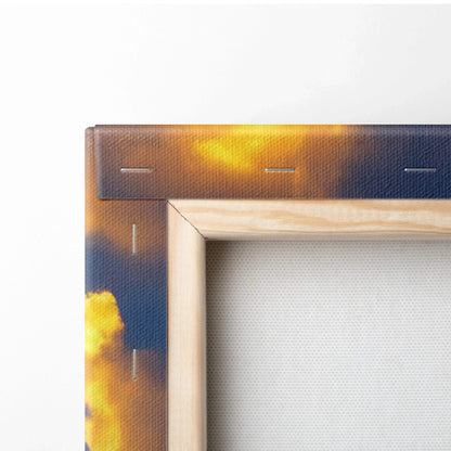 Close-up of canvas wall art corner showing wooden frame and sunset sky print with golden clouds.