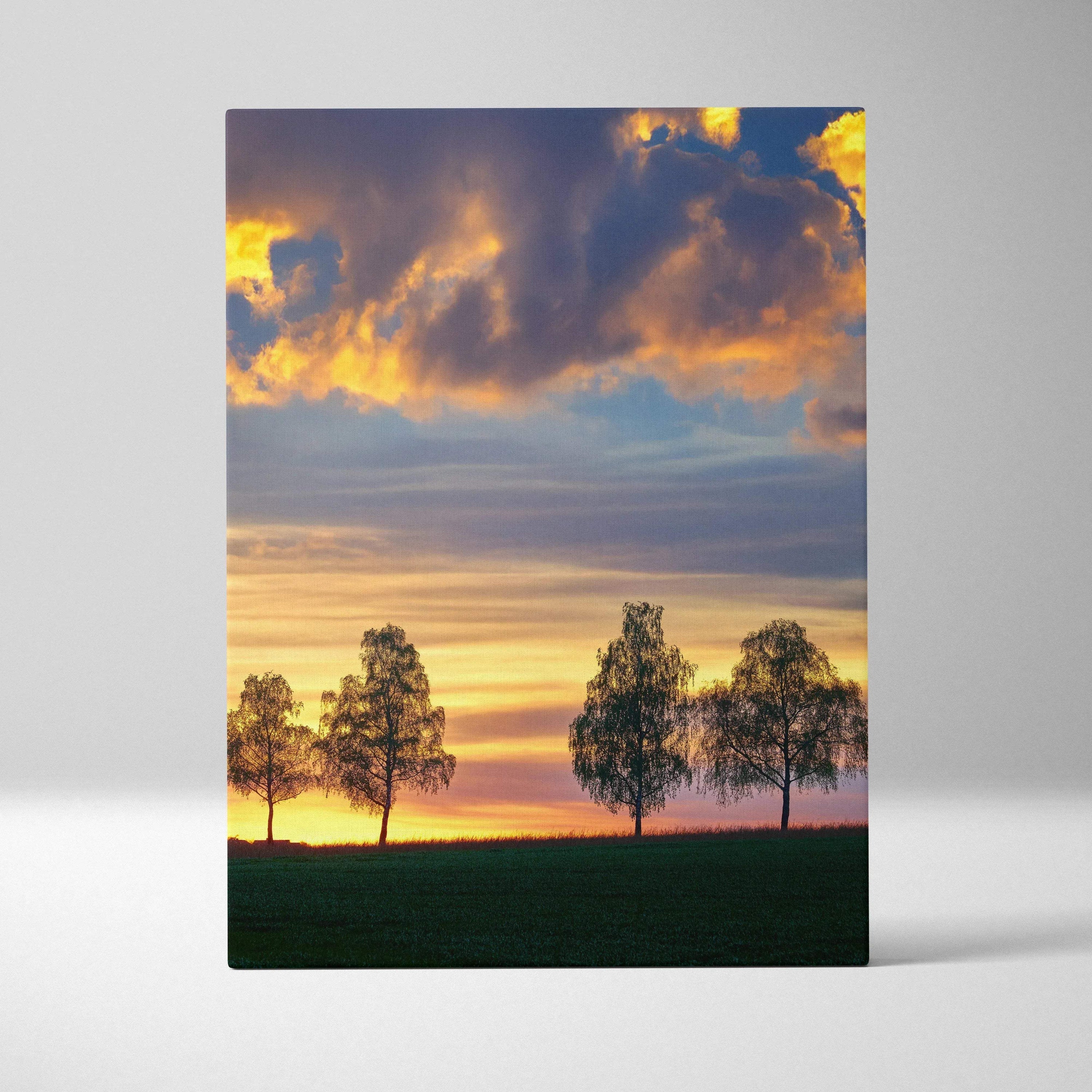 Sunset landscape canvas wall art with silhouetted trees under vibrant golden and blue sky.