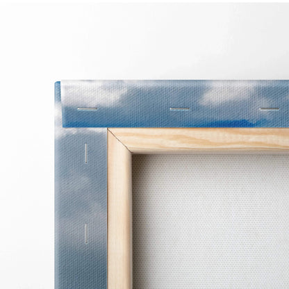 Close-up of stretched canvas corner with wooden frame and blue sky wall art print.