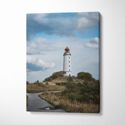 Coastal lighthouse surrounded by grassy dunes under cloudy sky canvas wall art print.