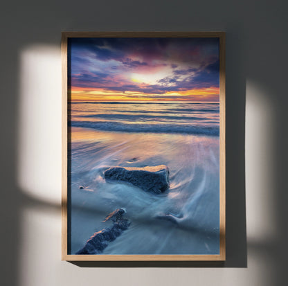 Vertical beach sunset ocean wall art poster with vibrant purple and orange sky over waves and rocks.