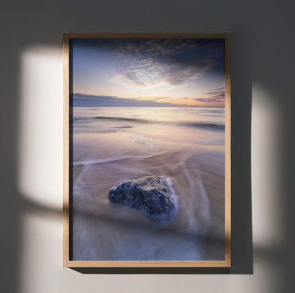 Vibrant beach sunset poster with soft ocean waves and a rock, vertical wall art.