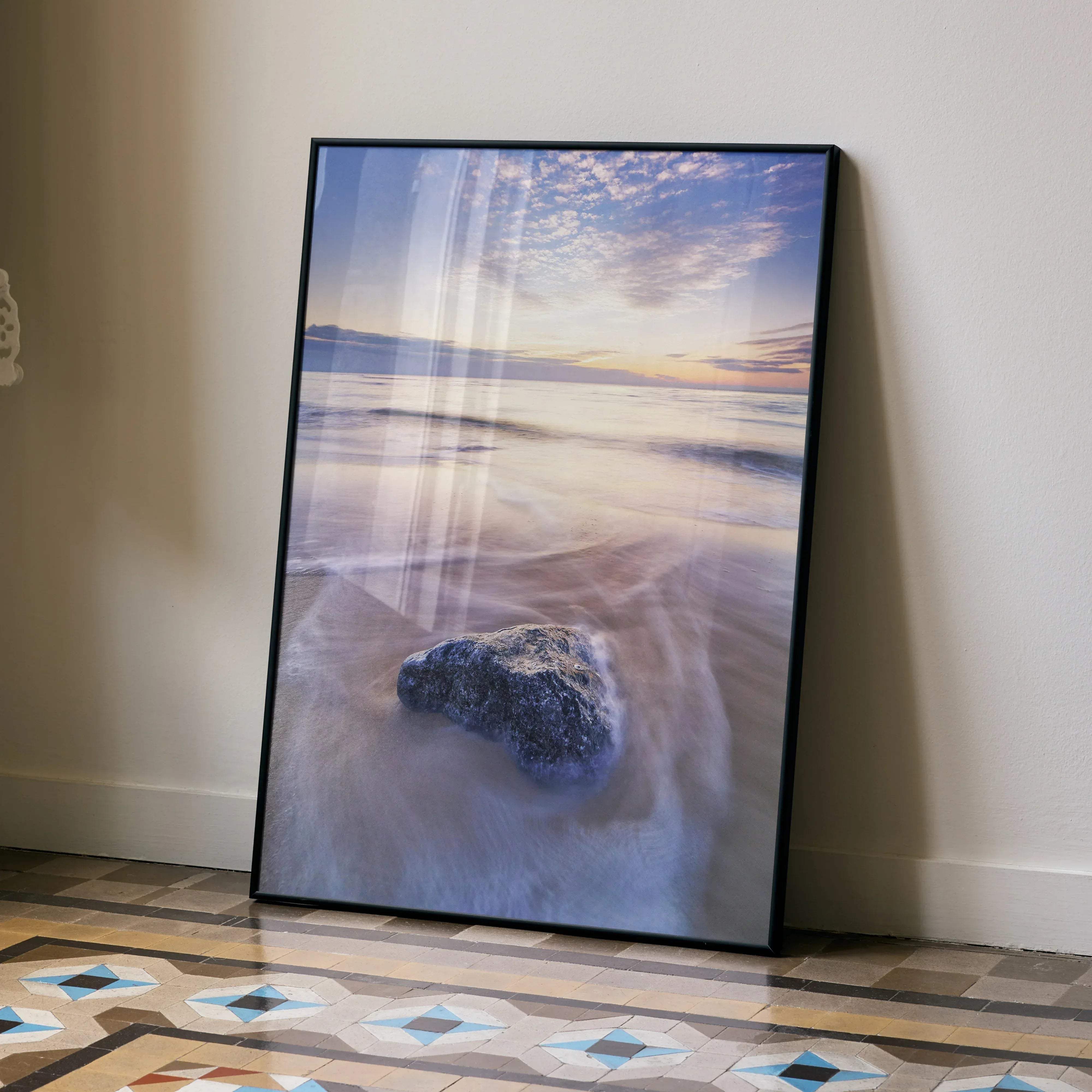 Black-framed vibrant beach sunset ocean wall art poster featuring a dark textured rock in the foreground vertical design