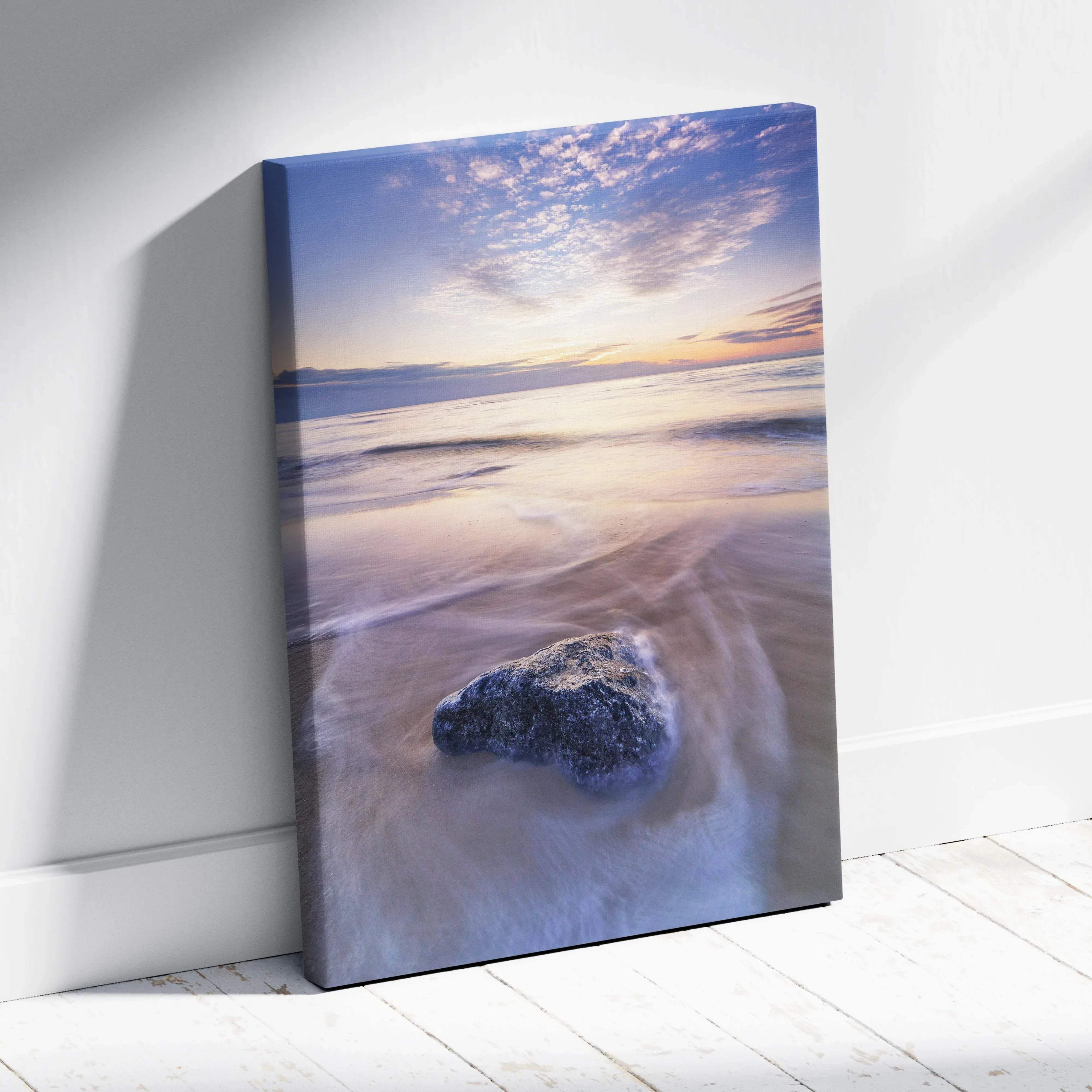 Tranquil beach sunset seascape canvas wall art featuring a dark textured rock under purple and gold skies