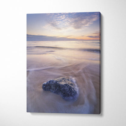 Canvas wall art featuring a tranquil beach sunset with soft clouds and a single dark rock in the foreground.
