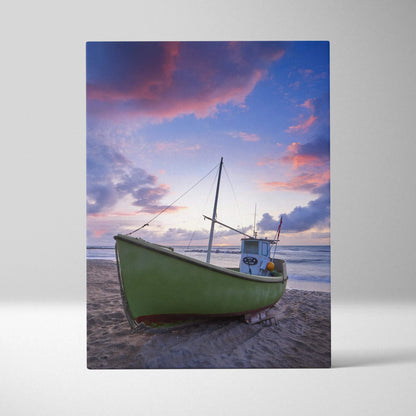 Canvas wall art featuring a green boat on a serene beach at vibrant sunset with pink and purple skies.