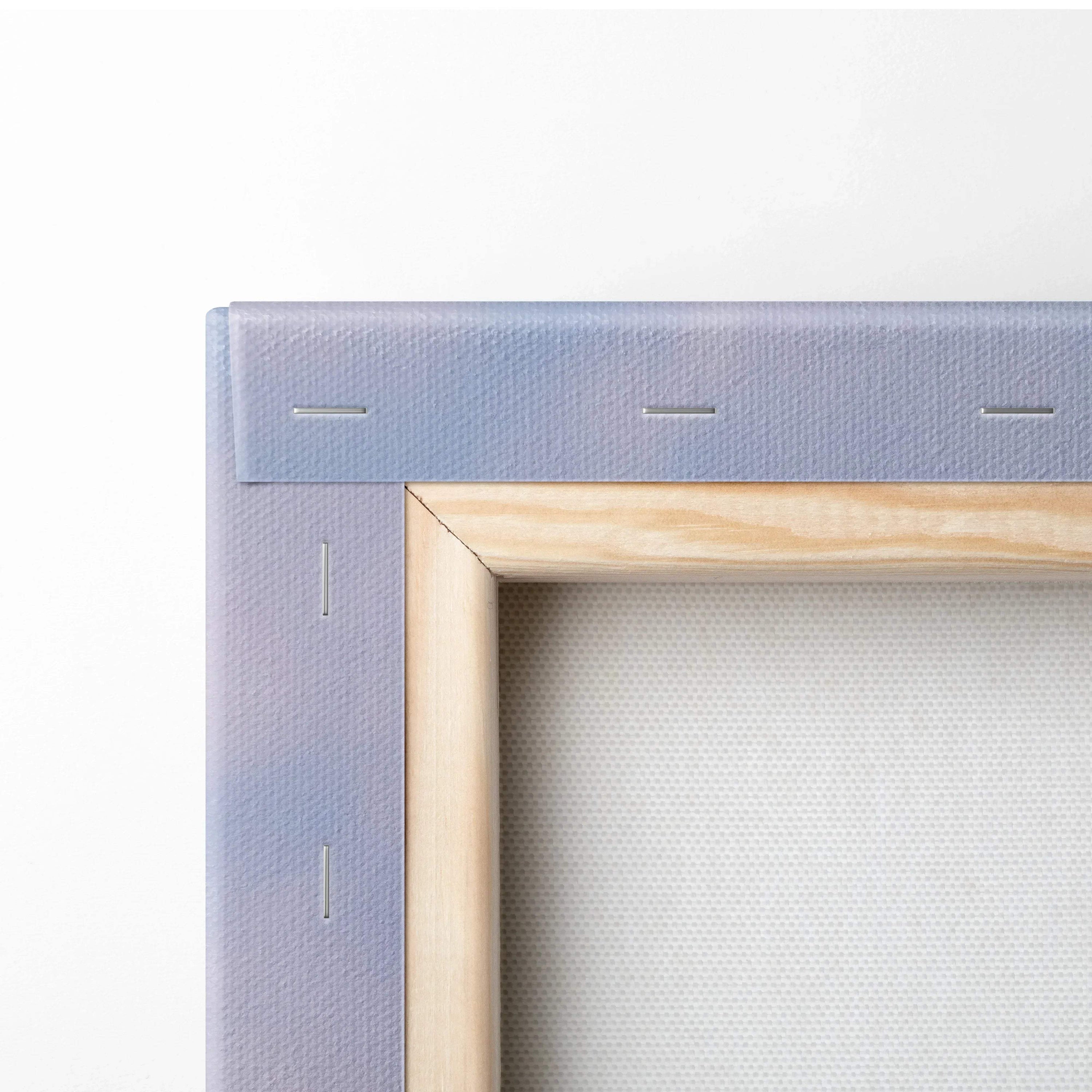 Close-up of wooden frame and staples on blue canvas wall art corner.