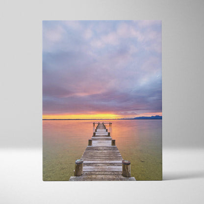 Vertical canvas wall art featuring a vibrant beach sunset with a wooden pier extending into calm water.