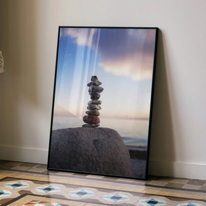 Vertical wall art poster featuring balanced stone stack on large rock under soft sunset sky.