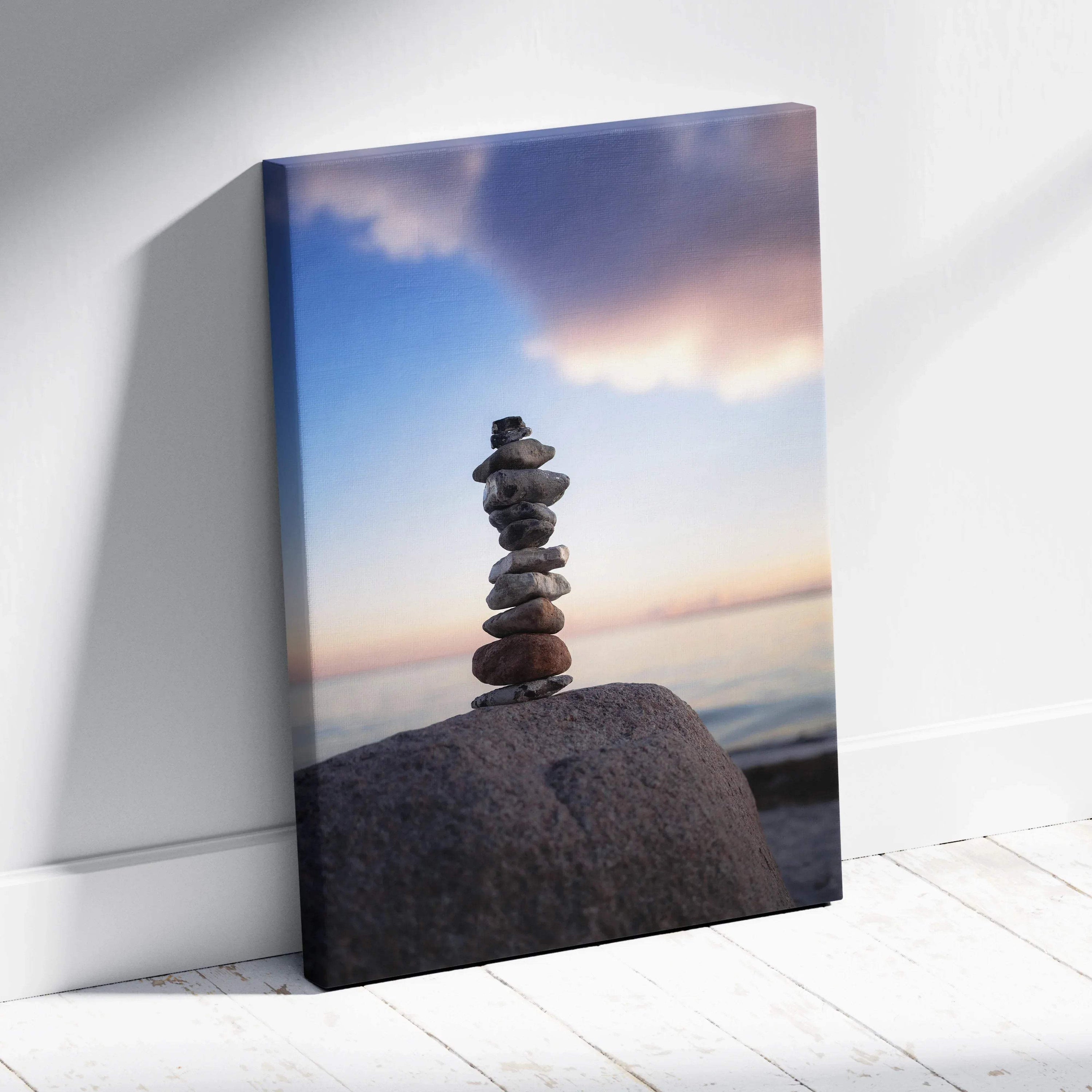 Canvas wall art featuring stacked beach stones against a colorful sunset sky.