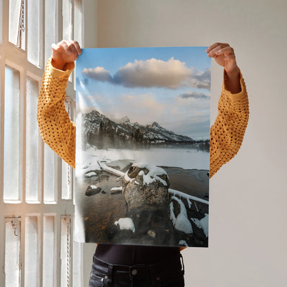 Vertical poster wall art showcasing snowy mountains and rocky lakeside under a blue sky with clouds.