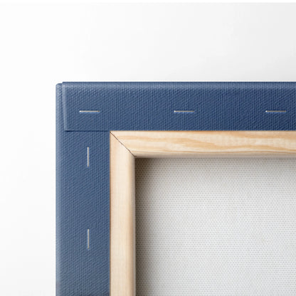 Close-up of wooden frame corner with blue canvas stretched and stapled on back of wall art.