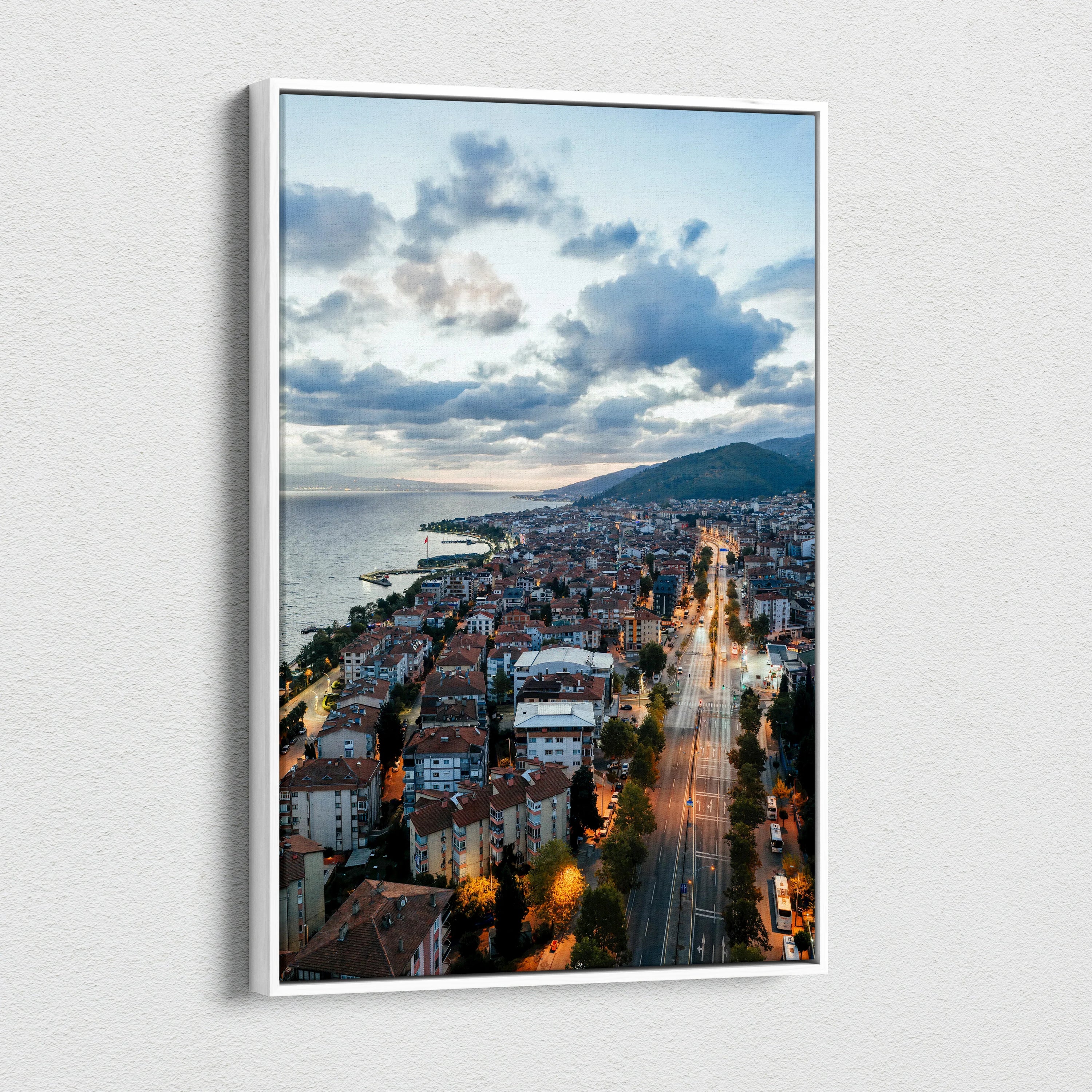 Vibrant city sunset canvas wall art showing illuminated buildings and streets along the coastline.