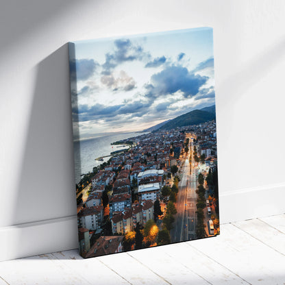 Canvas wall art featuring a vibrant cityscape at sunset with illuminated streets and cloudy sky.