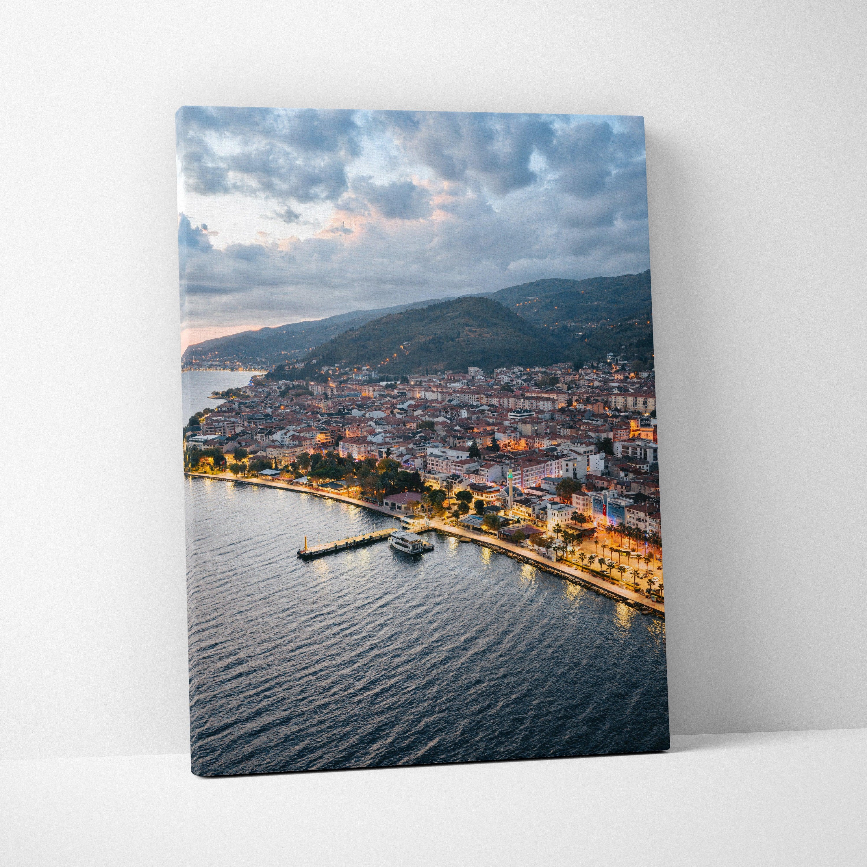 Canvas wall art featuring a vibrant city sunset over coastal buildings and water.