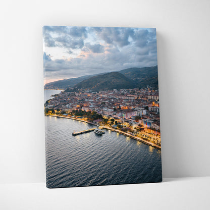 Canvas wall art featuring a vibrant city sunset over coastal buildings and water.