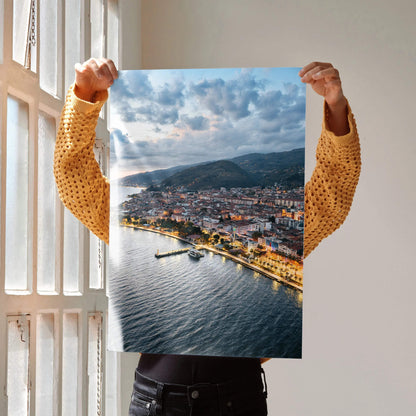 Vertical vibrant city sunset wall art poster showing illuminated shoreline and cloudy sky.
