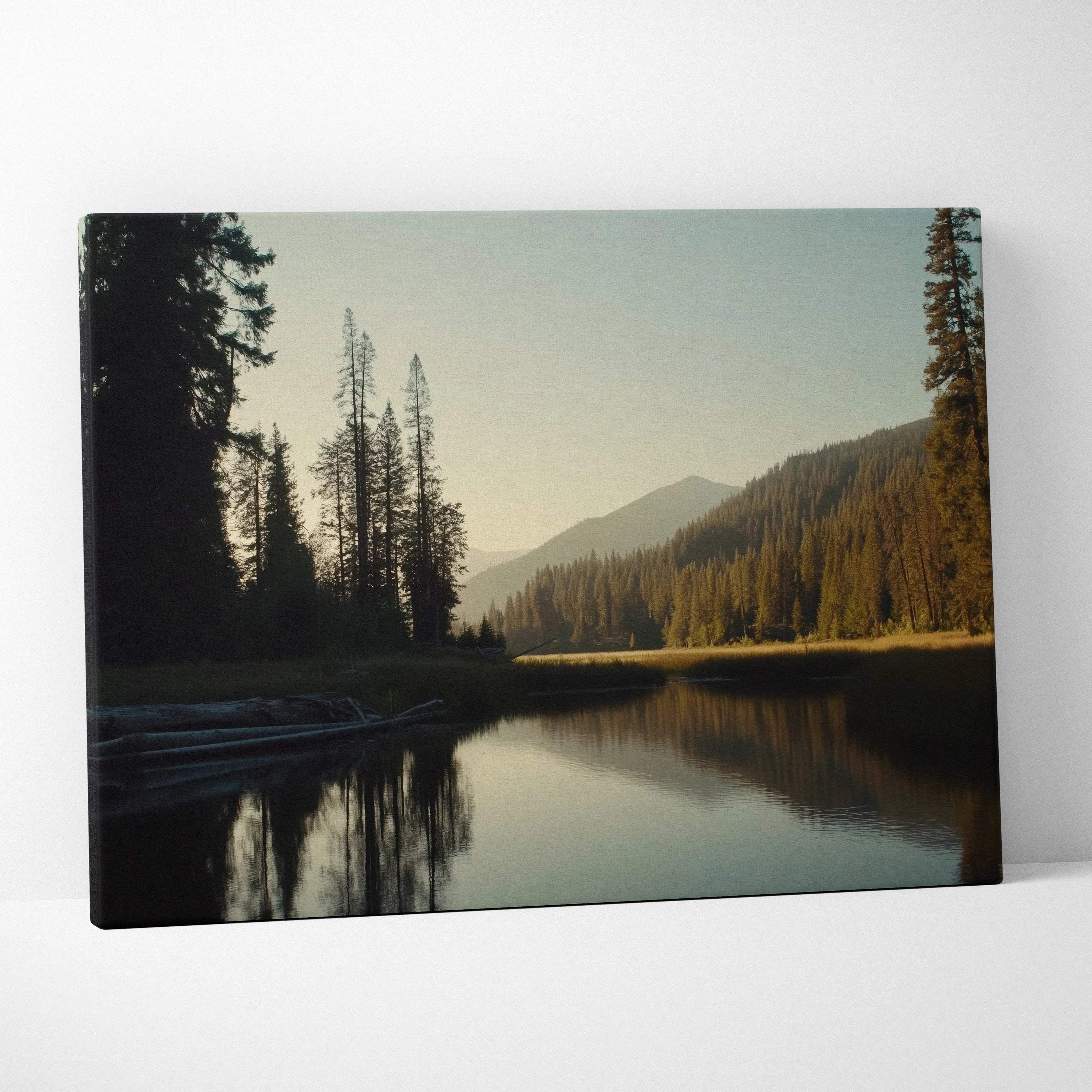 Canvas print of serene forest lake with mountains in golden hour light