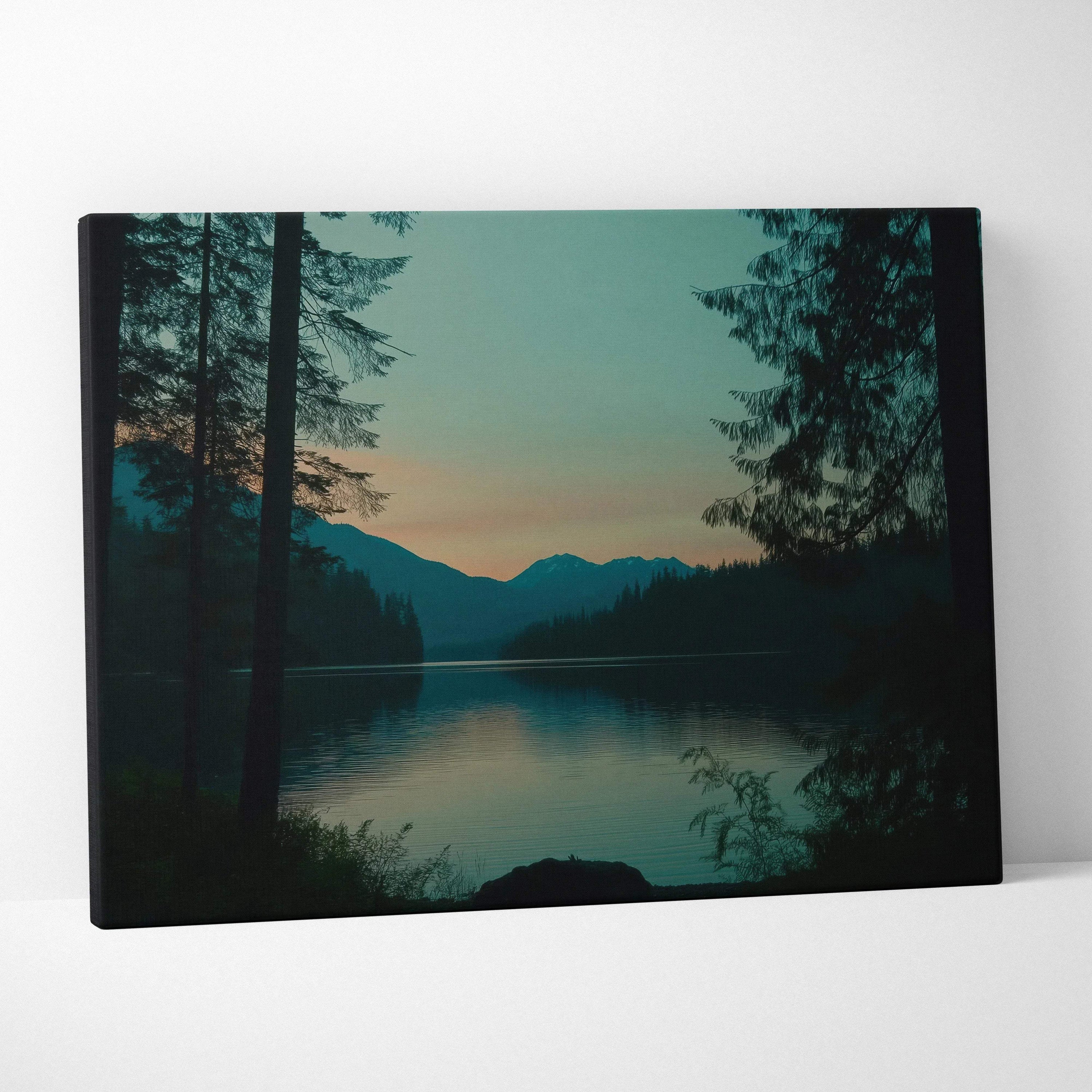 Black-framed canvas print of serene lake at dusk with mountains behind forest, calm sunset mood