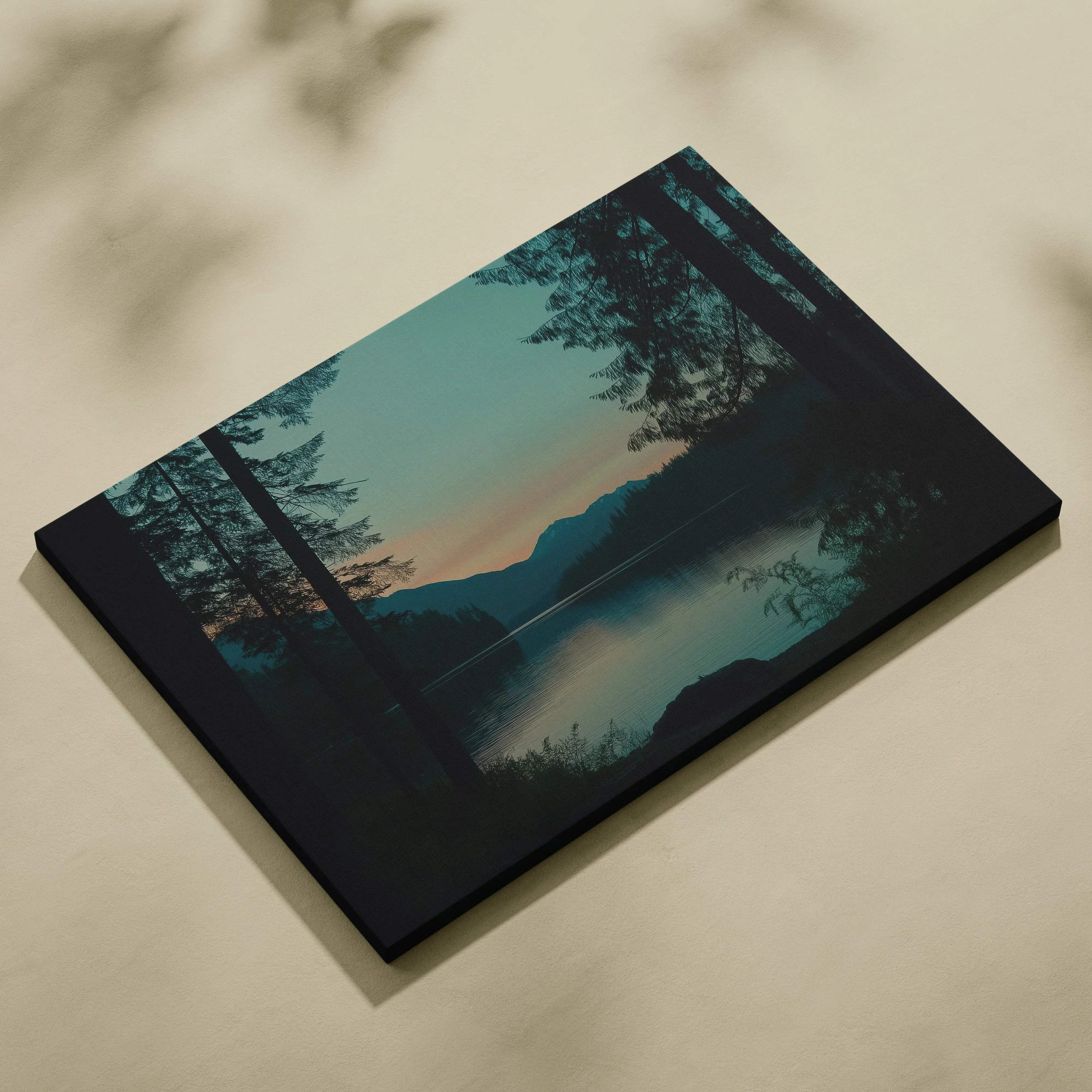 Black canvas print of serene forest lake at dusk with mountains, teal peach sunset hues
