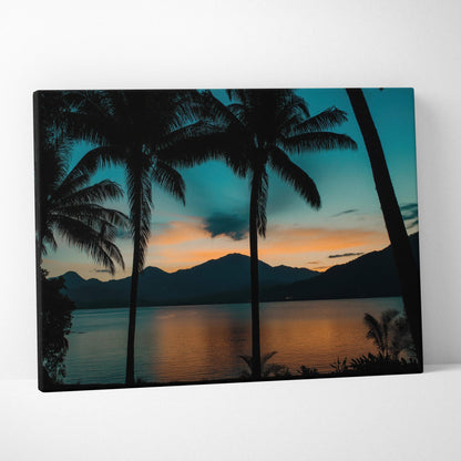 Canvas wall art of silhouetted palm trees at teal orange dusk over mountain lake