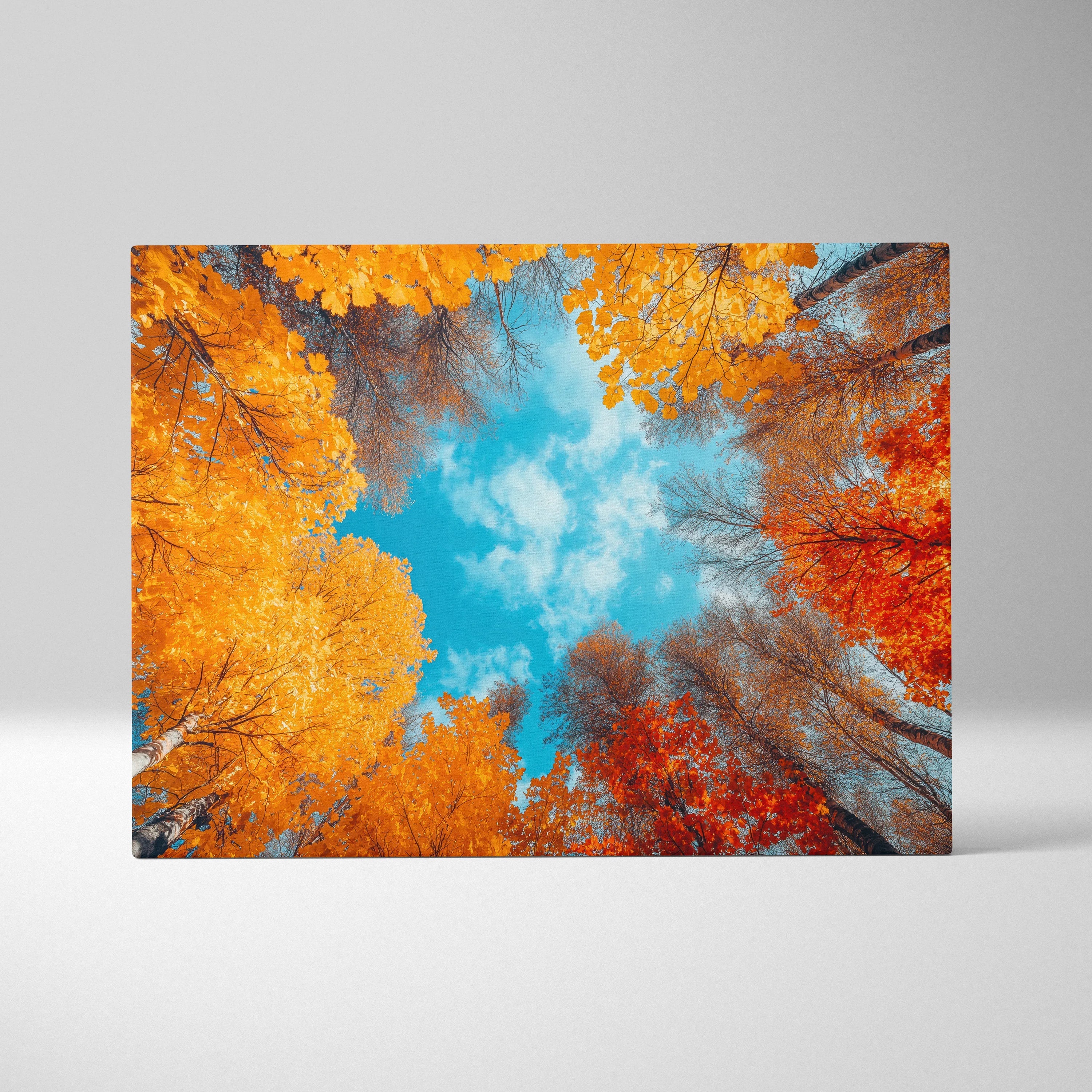 Autumn forest scene with vibrant orange and red leaves against bright blue sky on canvas wall art.