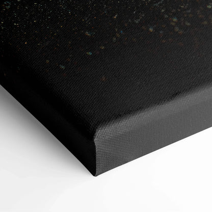 Black canvas stretched over wooden frame with subtle textured surface and small colorful speckles.
