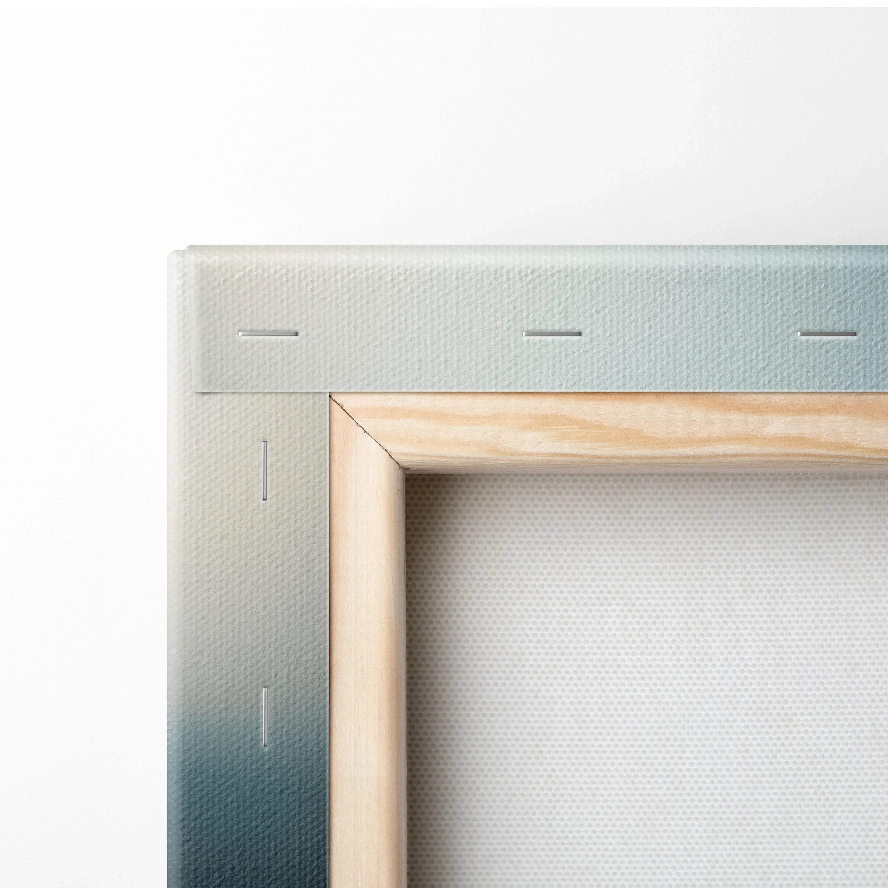 Close-up of stretched canvas corner with wooden frame and gradient blue-to-white painted edge for wall art decor.