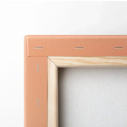 Close-up of stretched white canvas on wooden frame with peach-colored fabric backing and visible staples.